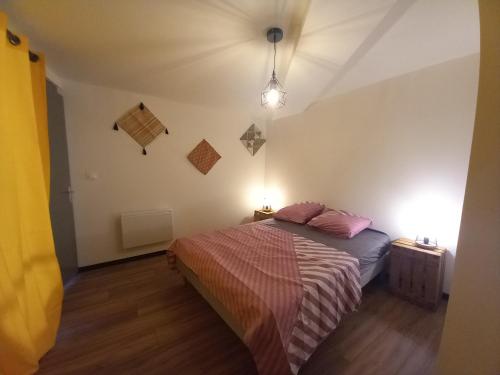 a bedroom with a bed with pink pillows on it at La terrasse du Clermontais in Clermont-lʼHérault