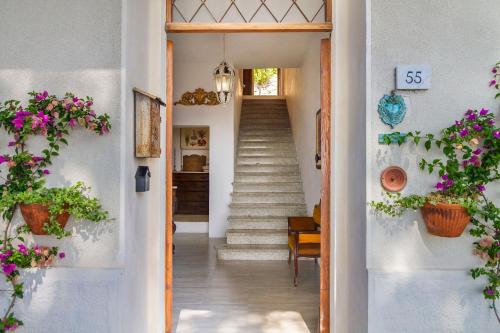 a hallway of a home with stairs and flowers at Casa Sole di Toscana con 5 camere, grande terrazza panoramica, giardino e vasca relax idromassaggio in Monterotondo