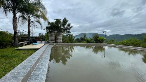 a swimming pool in a yard with trees and mountains at Monsonkeang Camping view ม่อนสันเกี๋ยง in Mae Chaem