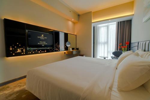 a hotel room with a bed and a flat screen tv at Sleeping Lion Suites in Kuala Lumpur