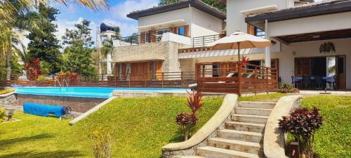 a villa with a swimming pool and a house at VILLA - MER - PISCINE - JARDIN in Foulpointe