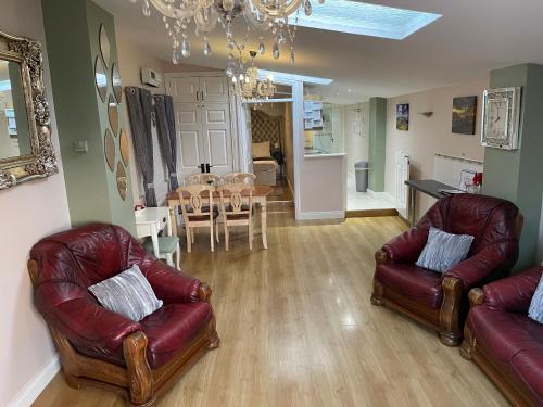 a living room with two leather chairs and a table at Cleomack View, Annexe apartment with Hot Tub in Hilltown