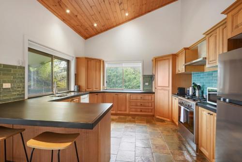 a kitchen with wooden cabinets and a counter top at Embrace Nature's Beauty in Ferny Creek in Ferny Creek