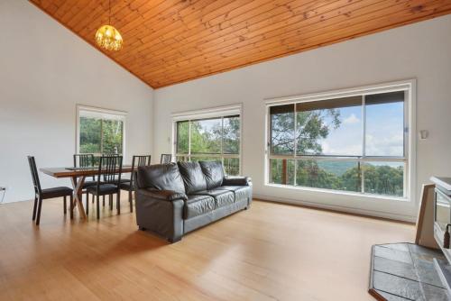 a living room with a couch and a table at Embrace Nature's Beauty in Ferny Creek in Ferny Creek