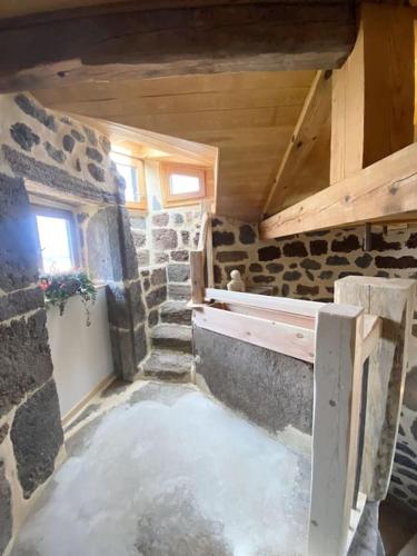 une chambre avec un mur en pierre et une chambre avec de l'eau dans l'établissement La maison forte du Goutay, à Vergezac