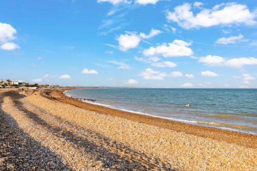 a beach with a rocky shoreline and the ocean at The Studio in Pevensey