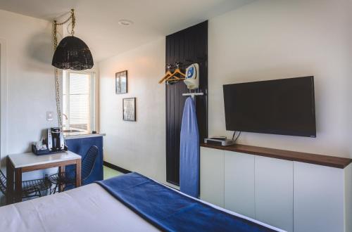 a room with a bed and a tv on a wall at Mylo Hotel in Daly City