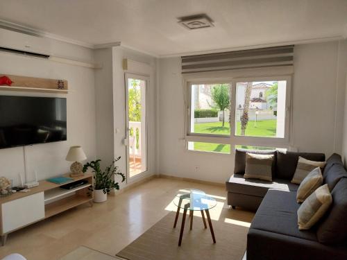 Una sala de estar con un sofá y un televisor. en Charming Apartment in front of Villamartin Golf And Plaza, en Villamartin