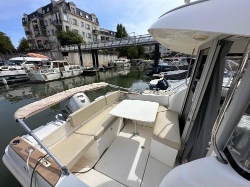 un bateau blanc garé sur un canal avec d'autres bateaux dans l'établissement FlW, à Cergy
