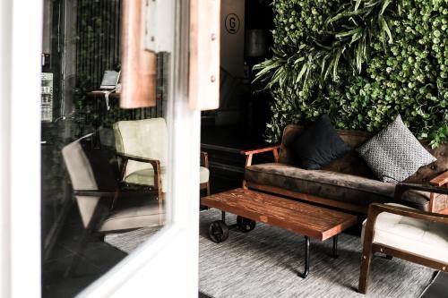 a couch and a coffee table in front of a plant at THA City Loft by TH District in Bangkok