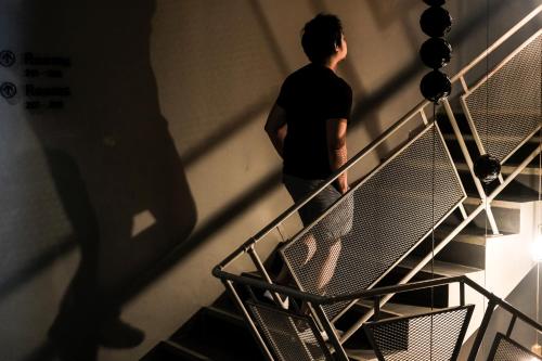 a man walking up a staircase in a building at THA City Loft by TH District in Bangkok
