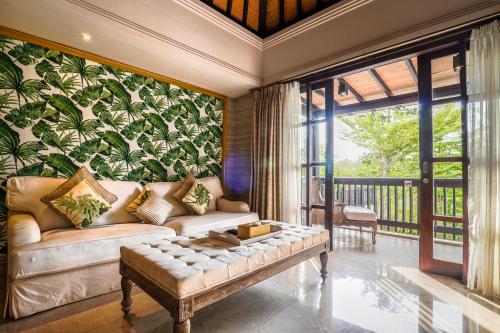 ein Wohnzimmer mit einem Sofa und einer Pflanzenwand in der Unterkunft The Springs Villas Jimbaran in Jimbaran