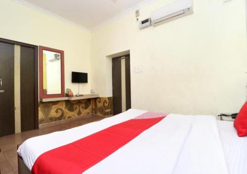 a bedroom with a white bed with a red blanket at Hotel Star INN in Jalandhar