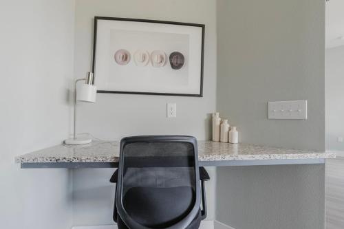 a desk with a black chair in a white room at Blueground Lost Plains pool pet area wd ATX-271 in Austin