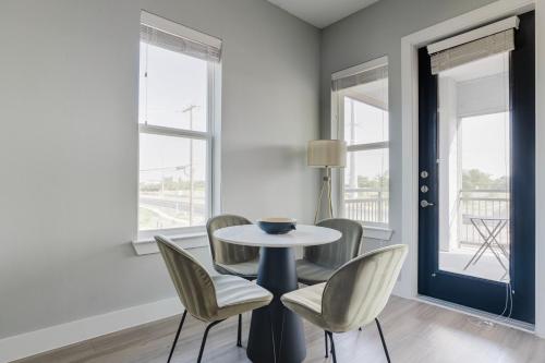 a dining room with a table and chairs and windows at Blueground Lost Plains pool pet area wd ATX-271 in Austin