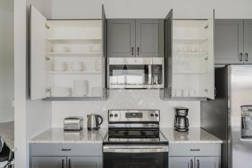 a kitchen with white cabinets and a stove at Blueground Lost Plains pool pet area wd ATX-271 in Austin