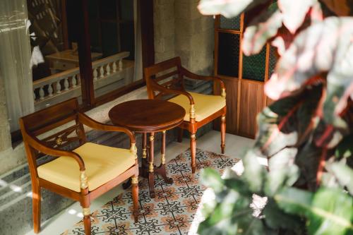 two chairs and a table on a balcony at Fourteen Roses Boutique Hotel, Kuta in Legian