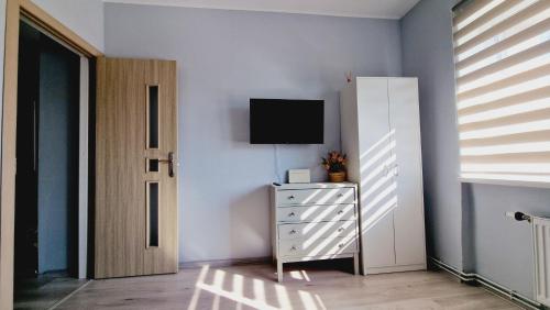 a bedroom with a dresser and a tv on a wall at SP Apartment Klaipedas street close to beach in Liepāja