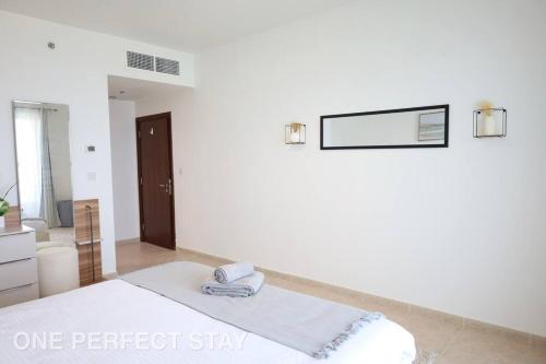 ドバイにあるStunning View 1 Bedroom Apartment Pool & Gymの白い部屋(ベッド1台、鏡付)