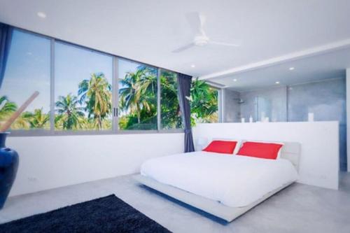 チャウエンノイビーチにある6-Bedrooms villa in Chaweng Noiのベッドルーム1室(白いベッド1台、赤い枕2つ付)