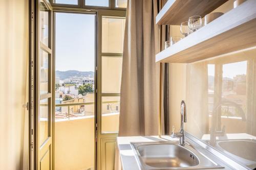 a kitchen with a sink and a window at Atlas Boutique Suites in Kavala