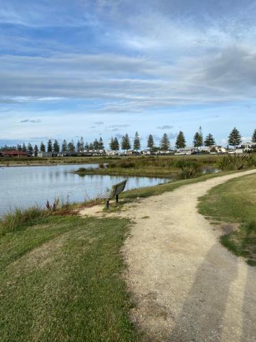 a park bench sitting next to a body of water at Parkview Home 5min from CBD in Napier