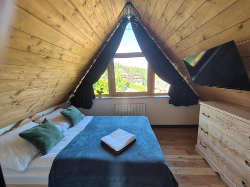 a bedroom with a large bed with a large window at Willa na Skarpie in Kościelisko