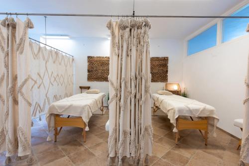 a room with four beds with curtains in it at La Bohème Lodges and Glamping in Vrhaveč