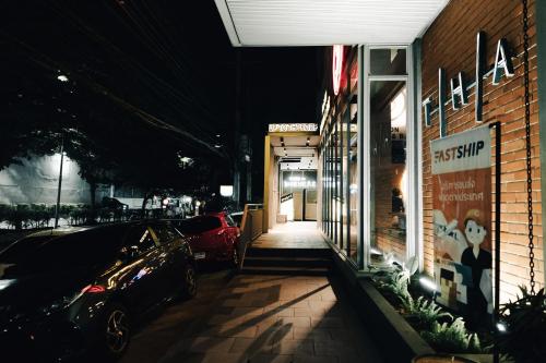 a car parked outside of a store at night at THA City Loft by TH District in Bangkok