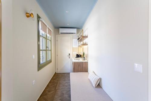 a hallway with a white door and a kitchen at Atlas Boutique Suites in Kavala