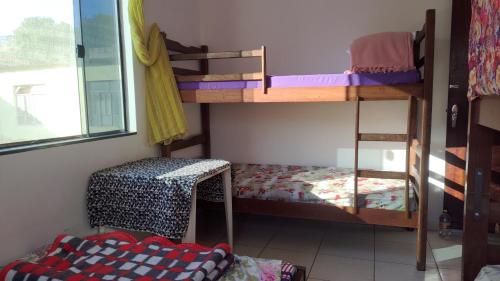 a room with two bunk beds and a chair at Hostel Meu Cantinho Caxambu Mg in Caxambu