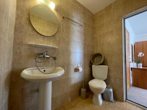 a bathroom with a sink and a toilet and a mirror at Alatoni Beach Hotel in Sozopol
