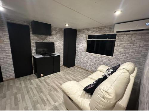 un salon avec un canapé et une télévision à écran plat dans l'établissement Jacuzzi mobile home bordure de lac, à Beaupouyet