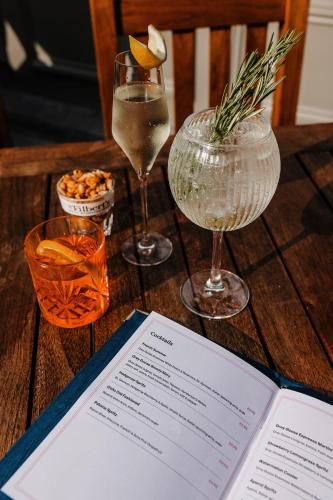a table with two wine glasses and a book on it at The Ashford Arms in Bakewell