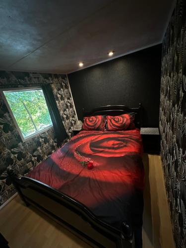 - une chambre avec un lit rouge et une fenêtre dans l'établissement Jacuzzi mobile home bordure de lac, à Beaupouyet