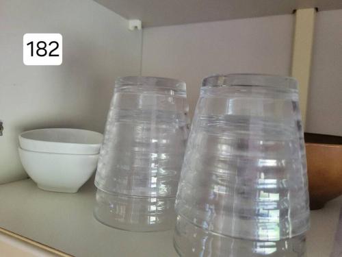 two clear plastic containers sitting on a counter next to a bowl at 小浜島 182号棟 in Kohama