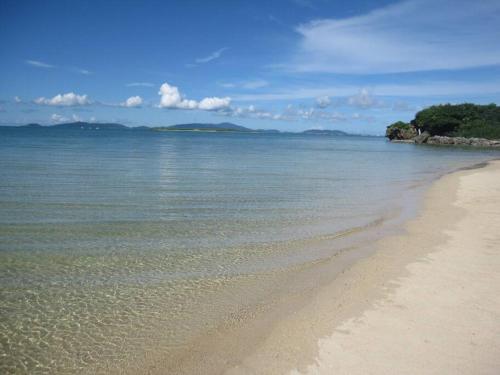 a sandy beach with trees and the ocean at 小浜島 182号棟 in Kohama