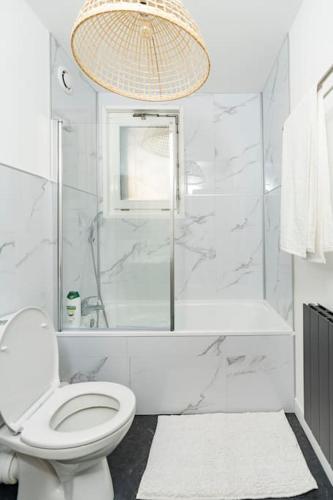 une salle de bain blanche avec toilettes et douche dans l'établissement Plein centre-ville T3 refait a neuf, à Saint-Simon