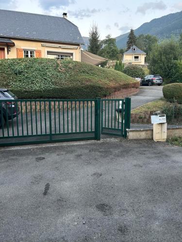 une clôture verte devant une maison dans l'établissement Saint-martin chantal, à Vier-Bordes