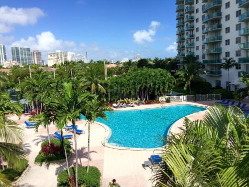 uma piscina num resort com palmeiras e edifícios em Ocean Reserve Miami Luxury Rentals em Miami Beach