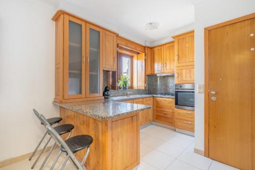 a kitchen with wooden cabinets and a counter top at Cantinho dos Fernandes in Ponte da Barca