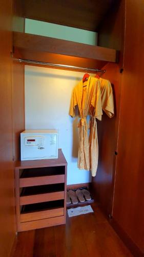 a room with a closet with a shirt and shoes at Mission Hills Phuket Golf Resort-SHA Extra Plus in Por Bay