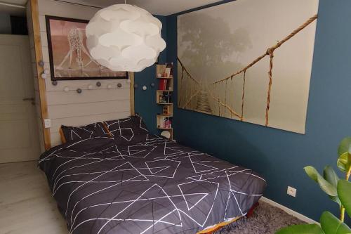 a bedroom with a bed with a blue wall at Maison proche de tout in Saint-Herblain