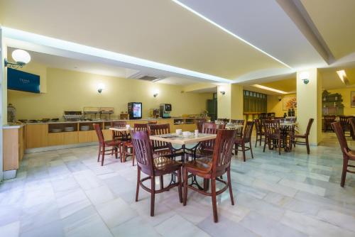 a restaurant with tables and chairs and a kitchen at Crisol Chiclana in Chiclana de la Frontera