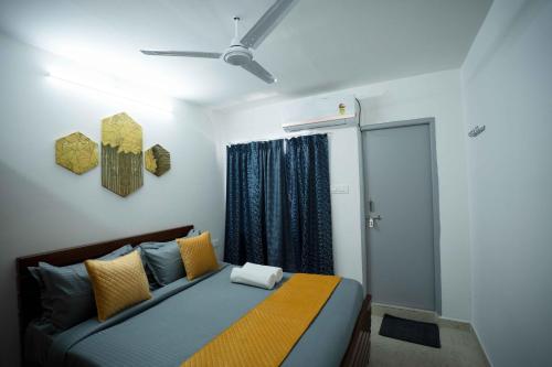 a bedroom with a bed with yellow and blue pillows at Yellow Bells Studios And Suites in Gachibowli