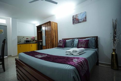 a bedroom with a large bed with towels on it at Yellow Bells Studios And Suites in Gachibowli