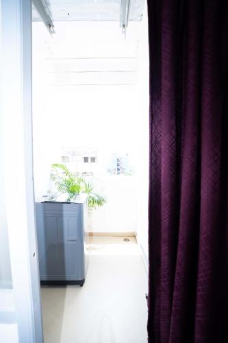 a room with a window and a purple curtain at Yellow Bells Studios And Suites in Gachibowli