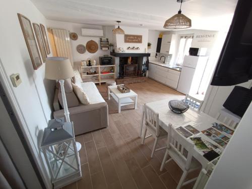 a living room with a couch and a table at Maison berrichonne WiFi jardin linge in Aigurande