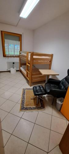 a room with a table and two bunk beds at Lunga Via Delle Dolomiti in Calalzo