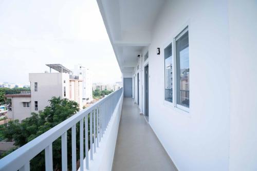 a balcony of a white building with windows at Yellow Bells Studios And Suites in Gachibowli